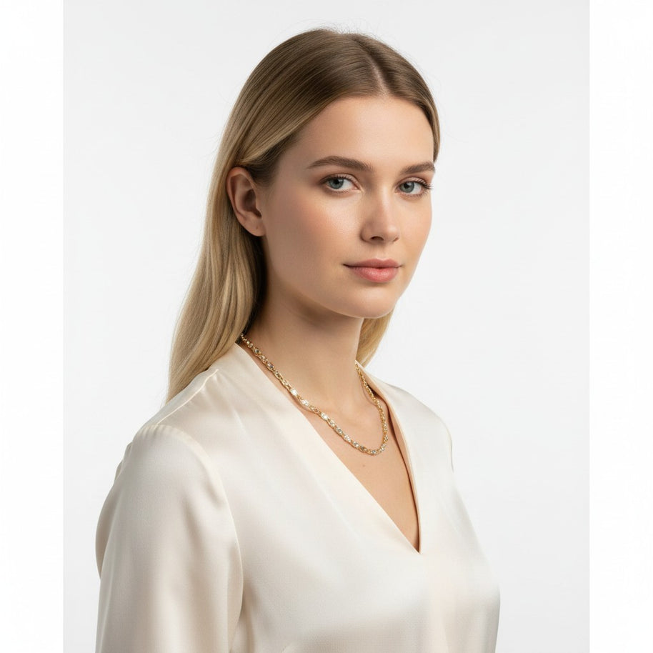 A model wearing a TYS Jewelers 10K gold trio color Valentino chain with a sleek V-neck blouse
