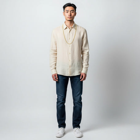 A man wearing a TYS Jewelers 10K yellow gold mariner chain over a beige linen shirt against a plain background.