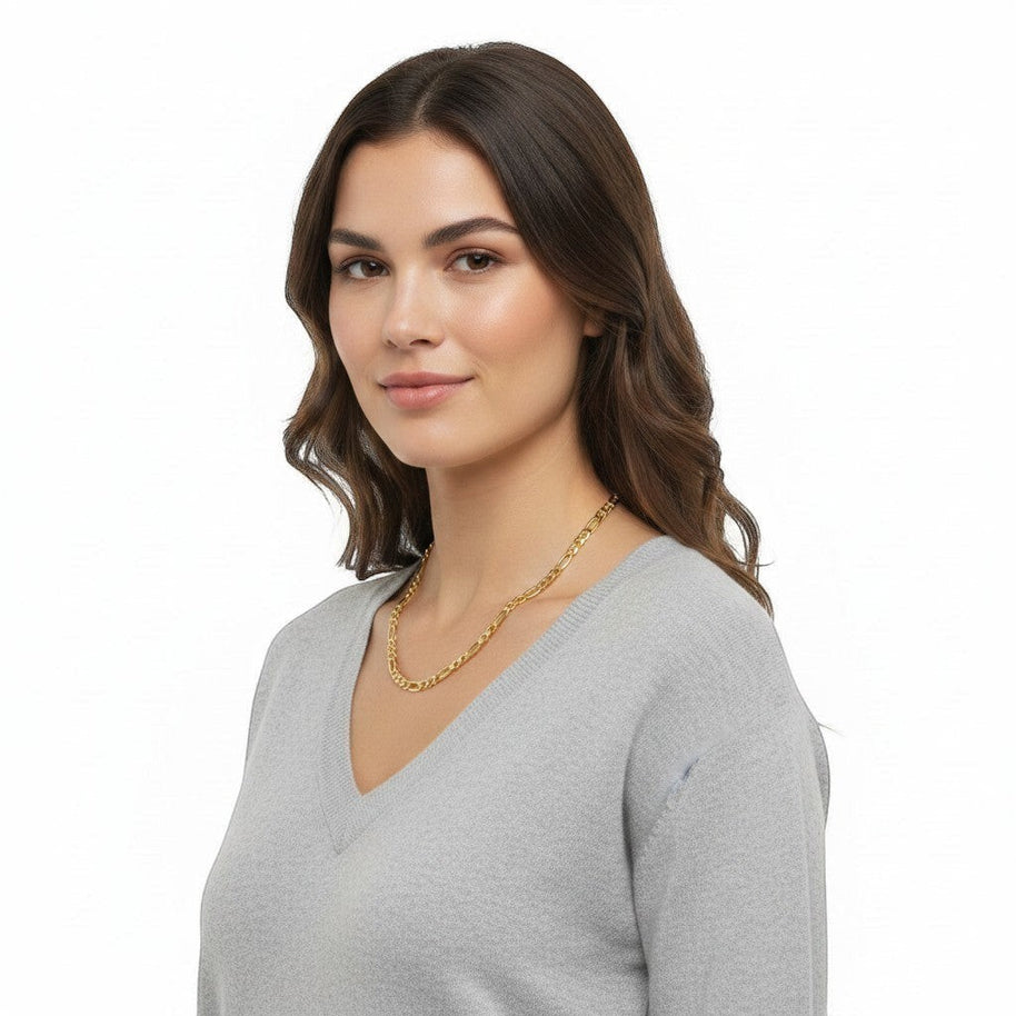 TYS Jewelers 10K yellow gold two-tone diamond-cut figaro chain worn by a woman in a grey V-neck sweater